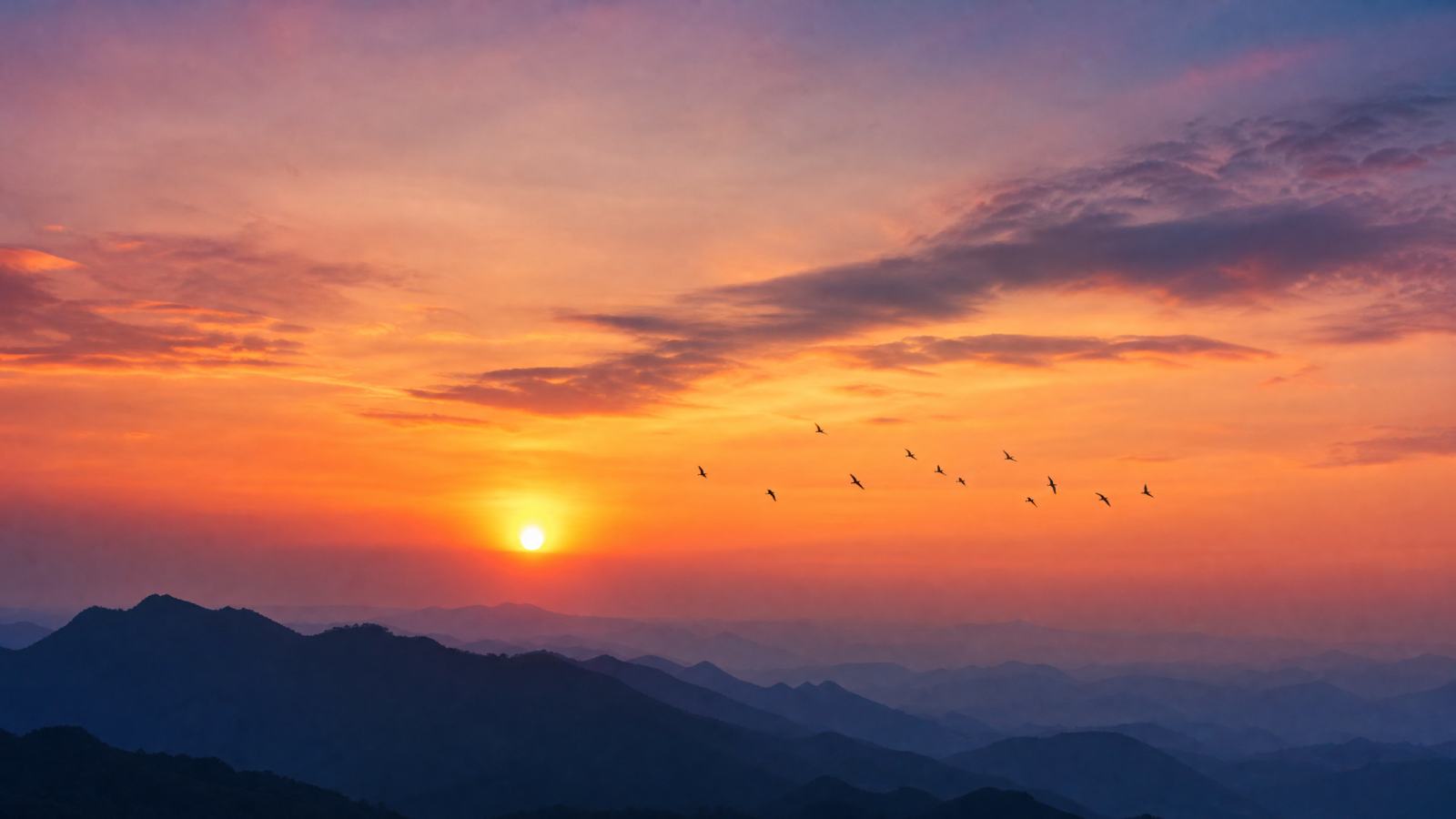 夕阳下的山峦剪影，天空呈现橙色与紫色渐变，远处有飞鸟，摄影风格，高清晰，16:9 - 唯爱图库